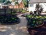 Stone walkway weaving through planted flower beds