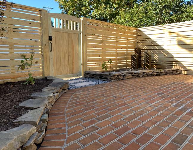 Back yard of the same property with new fence, gate, hardscaping and water feature 